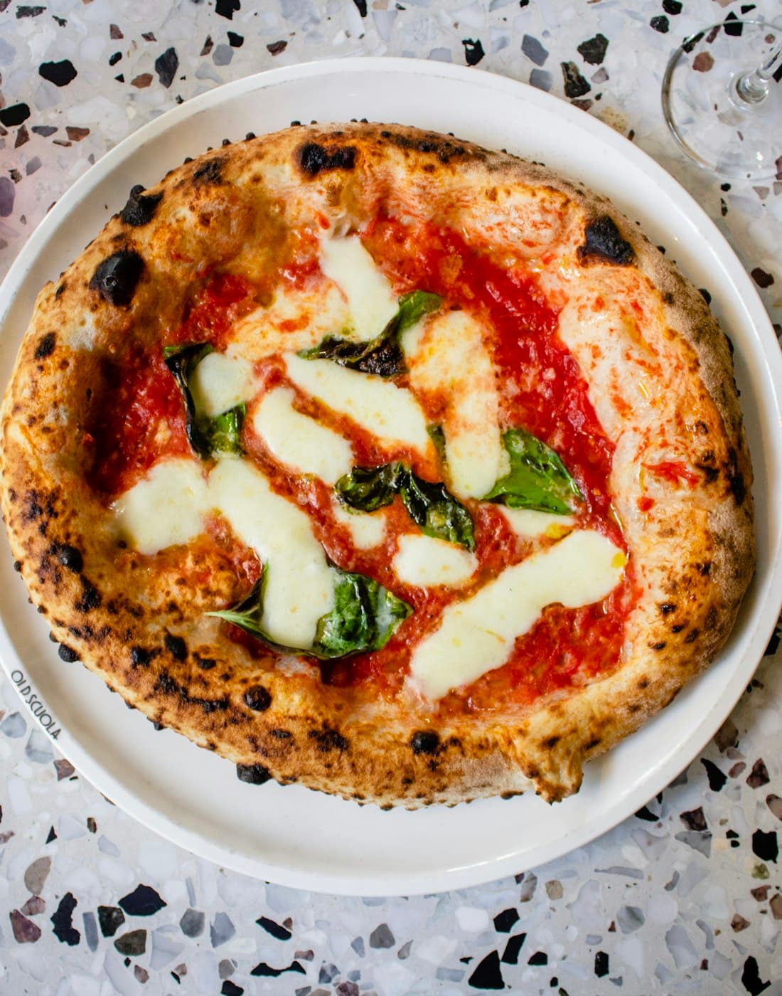 A margherita pizza on a white plate