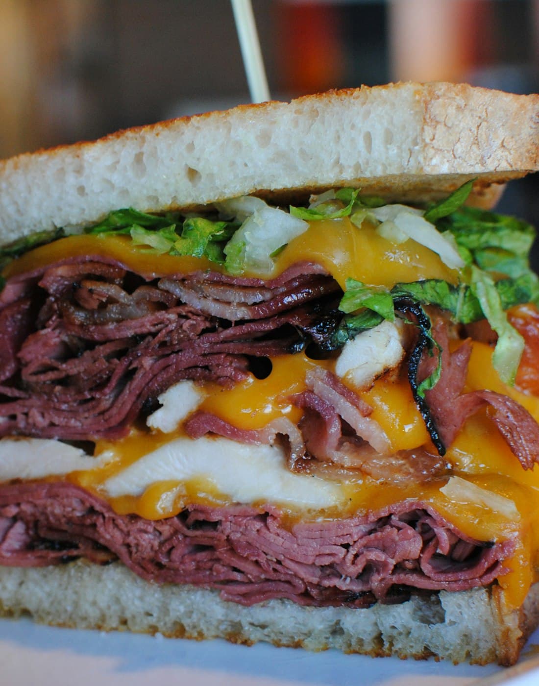 A pastrami sandwich with melted cheese