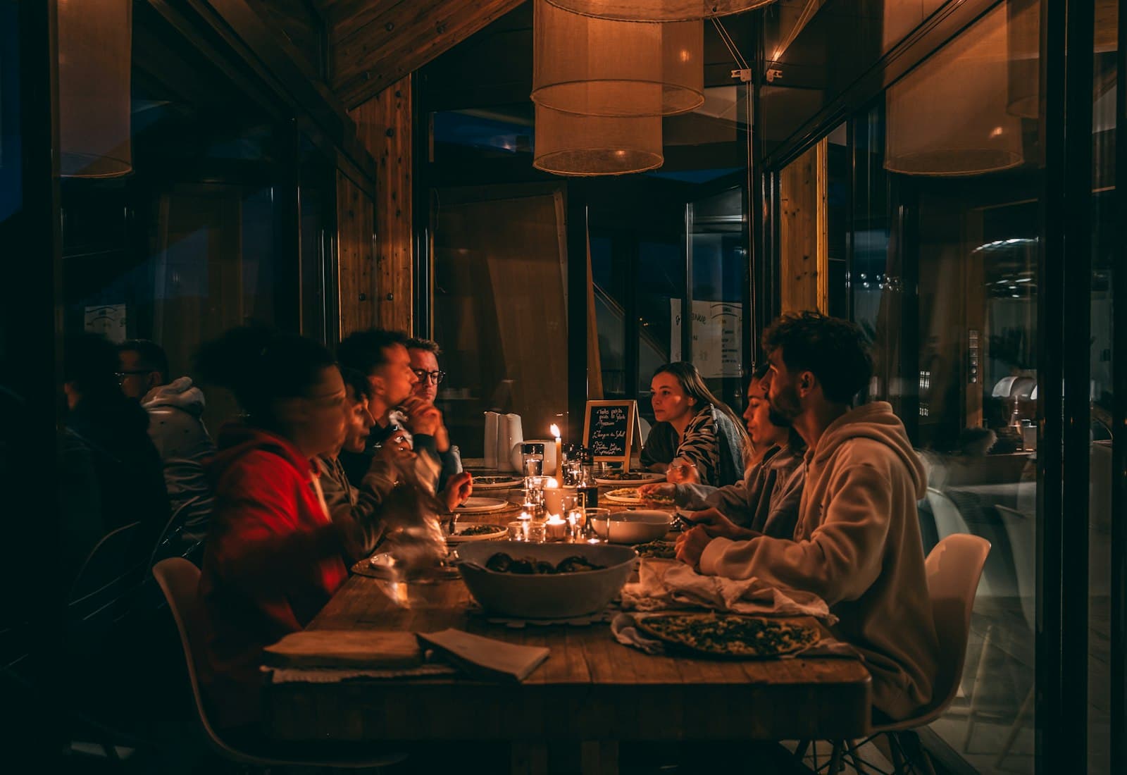 People sharing a meal at a candlelit restaurant table
